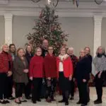 Smiling people in front of Christmas tree