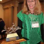 Woman standing near the trophy best club dogwood district