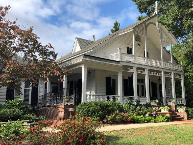 A large white house with a porch and balcony.