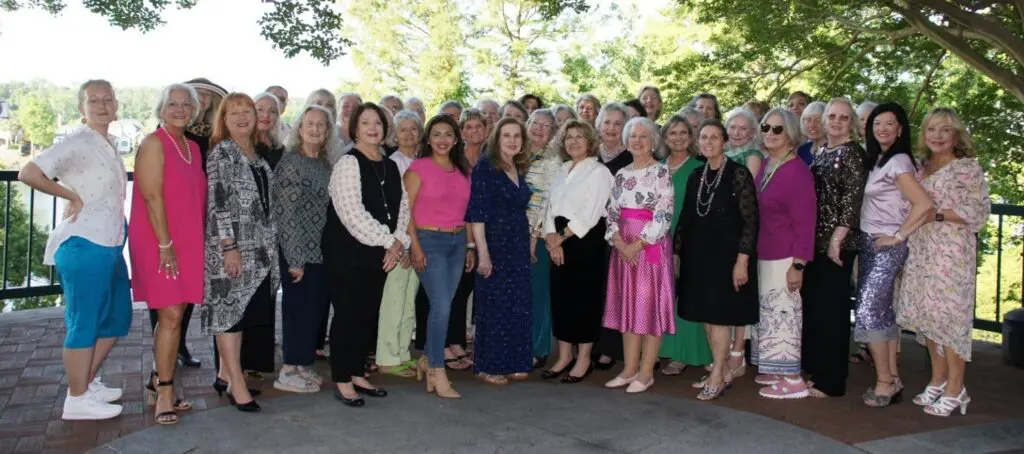 A group of women posing outdoors in casual and semi-formal outfits.